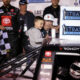 Kyle Busch and his son, Brexton, 4, apply the winner sticker to his truck after winning the Str ...