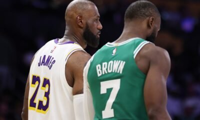 LeBron James talks to Jaylen Brown on the court.