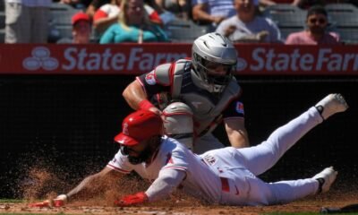 Los Angeles Angels' Luis Rengifo, below, is tagged out by Cleveland Guardians catcher Austin Hedges while trying to score after Jorge Soler hit into a fielder's choice during the third inning of a baseball game Sunday, April 6, 2025, in Anaheim, Calif.