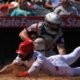 Los Angeles Angels' Luis Rengifo, below, is tagged out by Cleveland Guardians catcher Austin Hedges while trying to score after Jorge Soler hit into a fielder's choice during the third inning of a baseball game Sunday, April 6, 2025, in Anaheim, Calif.